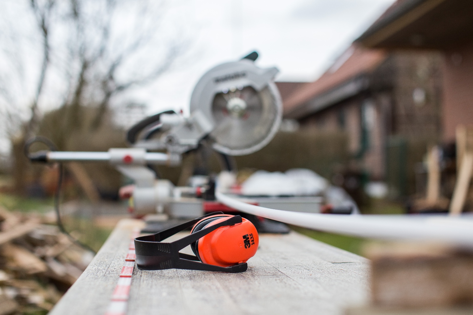 Earmuffs on bench next to circular saw