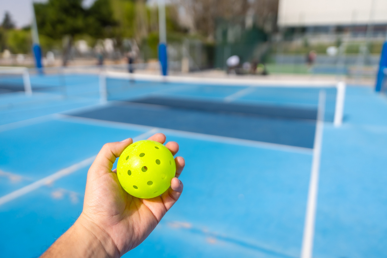 A player prepares to serve a pickleball